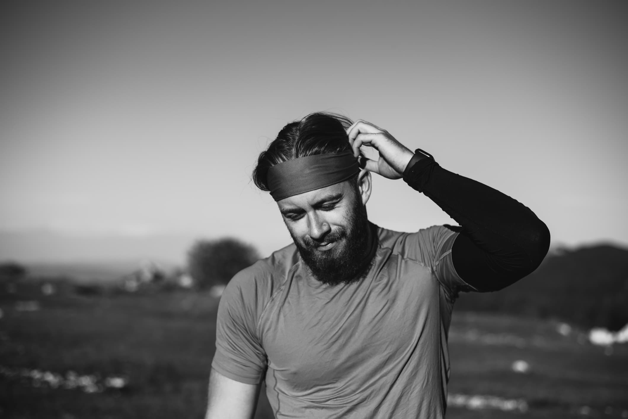Athlete adjusting headband, preparing for training at sunrise